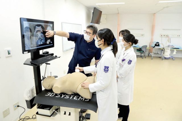 妊婦の腹部超音波検査を高性能シミュレータで練習している様子